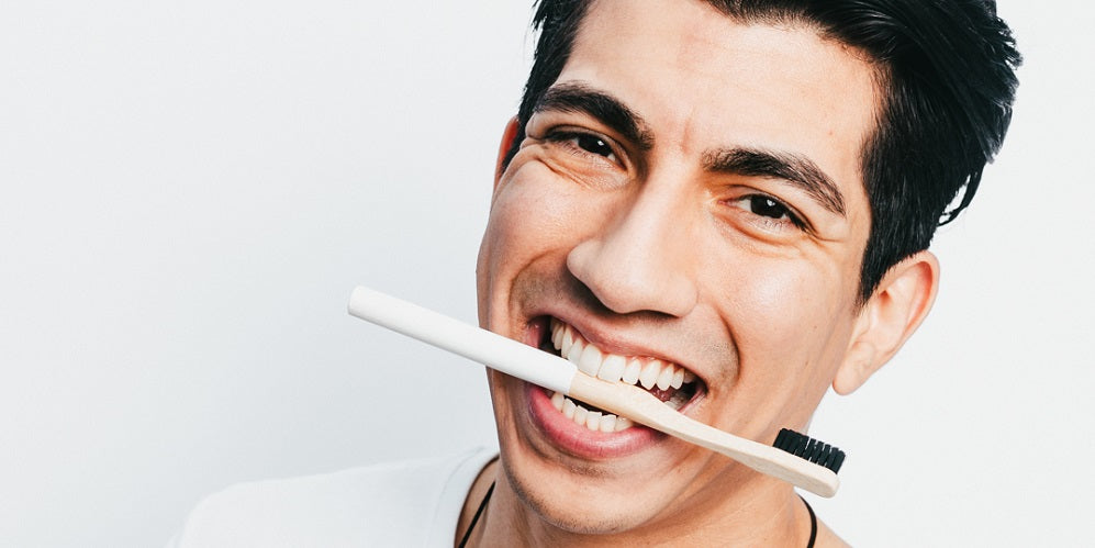 man with bamboo toothbrush in mouth
