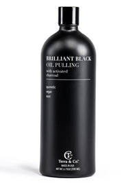 Black bottle of 'Brilliant Black Oil Pulling' with activated charcoal by Terra & Co on a white background