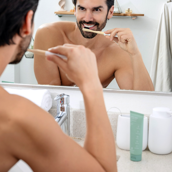 Man brushing teeth with Terra & Co. Gentle Green Toothpaste as part of a clean, minimalist oral care routine
