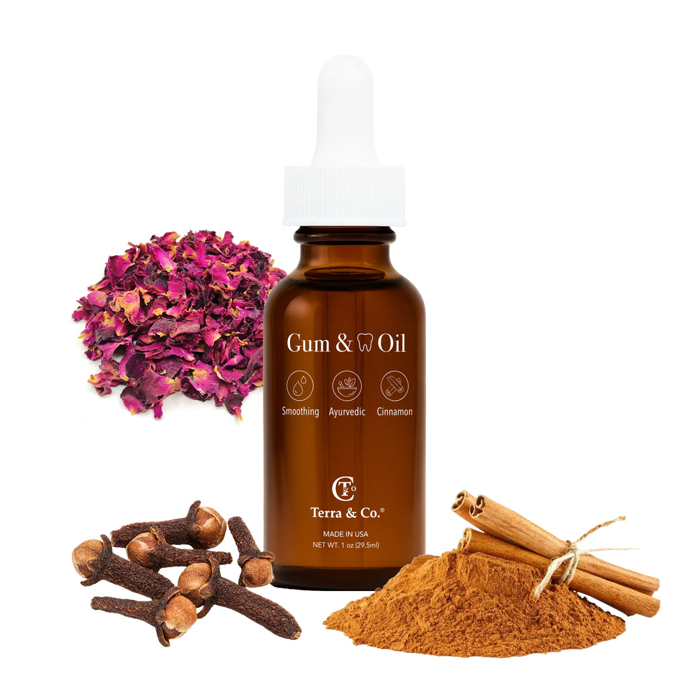 Bottle of Gum & Oil with spices and flowers on a white background