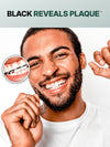 Black Reveals Plaque™ – man flossing with Brilliant Black® black charcoal dental floss; magnified close-up shows plaque removed from between teeth