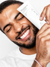 Man holding Brilliant Black® Toothpaste – fluoride-free, vegan charcoal toothpaste for a clean and confident smile
